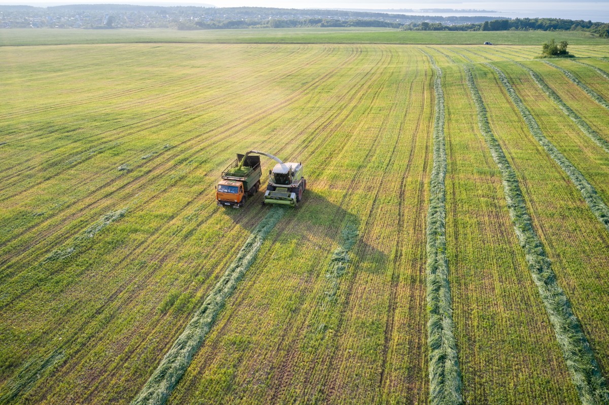 Drone view of farm equipment moving through field